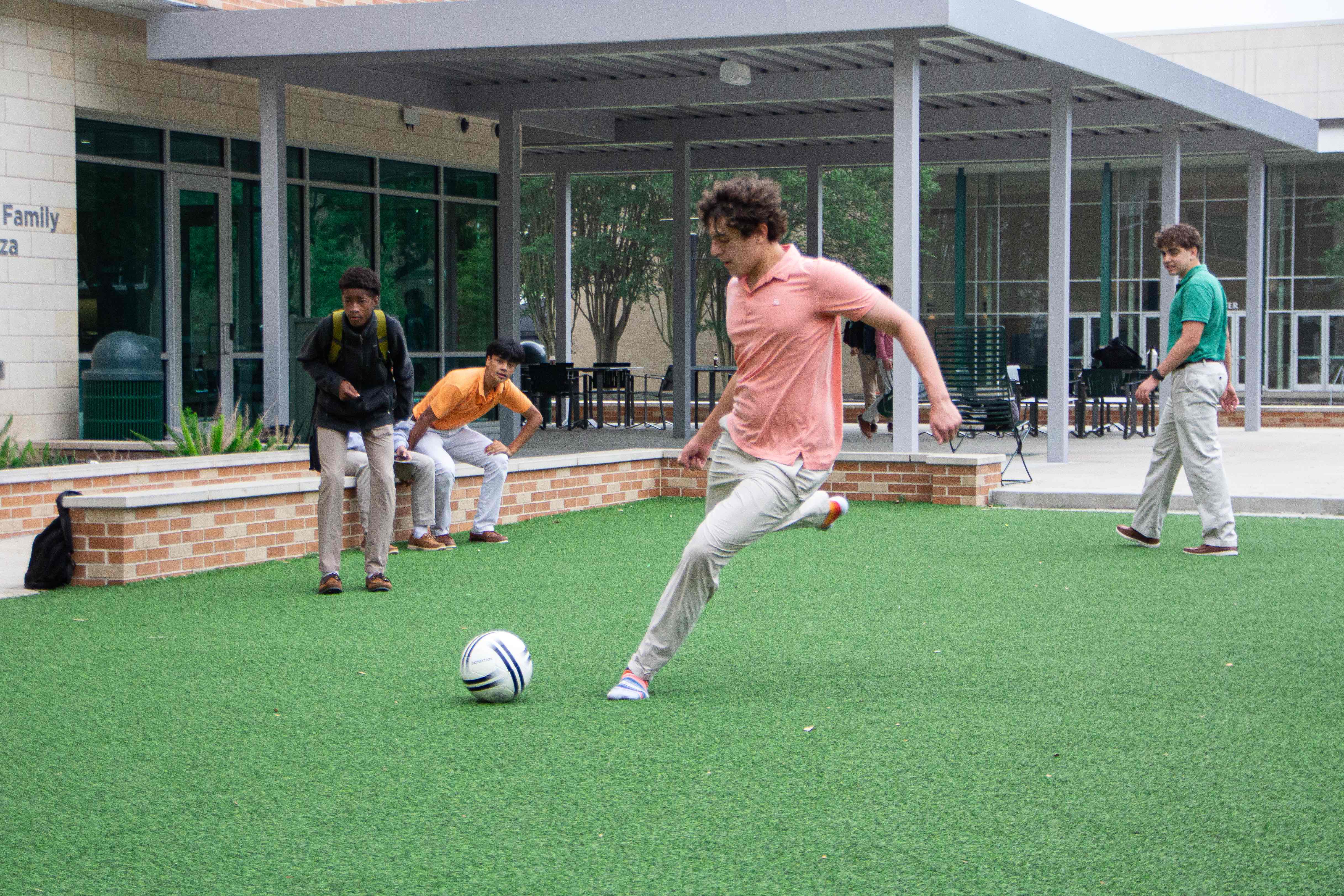 Student playing futbol on campus